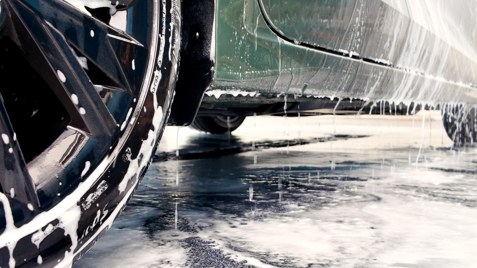 Auto met schuim op een chemie- en waterbestendige Duraquartz Torffelvloer in de wasstraat van TipTop Carwash